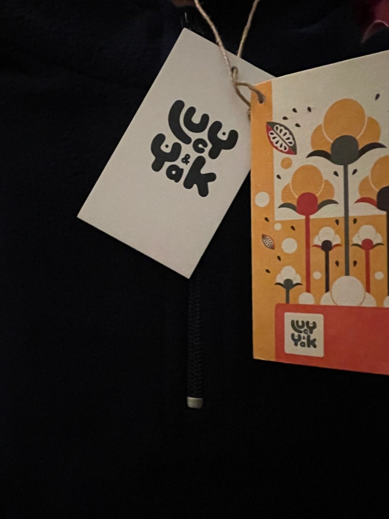 A blue fleece with a paper label attached.