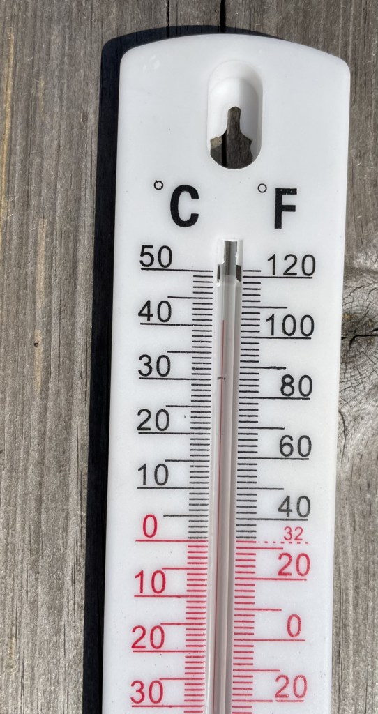 A thermometer outside in the sun showing 41 degree C. 